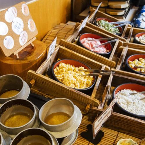 a buffet with bowls of different types of food at Kyukamura Irago in Tahara