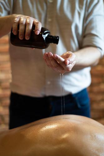 a person is holding a bottle of liquid in their hands at Wellness Hotel Volarik in Mikulov
