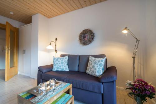 a living room with a blue couch and a table at Ferienwohnungen Alpentraum - Pusteblume in Obermaiselstein