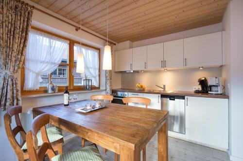 a kitchen with a wooden table and some chairs at Ferienwohnungen Alpentraum - Pusteblume in Obermaiselstein