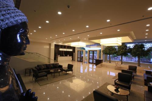 a lobby of a building with chairs and tables at Goutham Grand Hotel in Tenāli