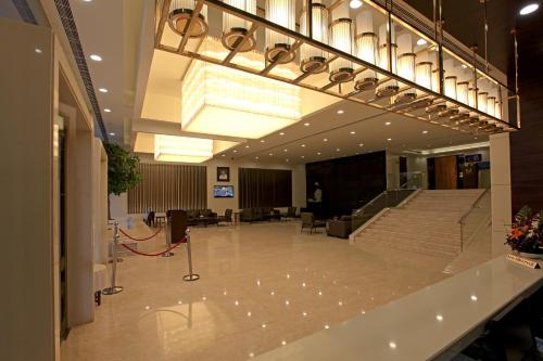 a large lobby with a staircase in a building at Goutham Grand Hotel in Tenāli