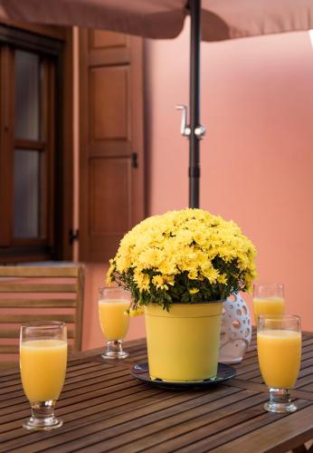 a table with a pot of flowers and glasses of orange juice at Palazzo di Irene in Chania Town