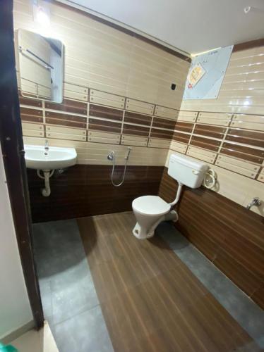 a bathroom with a toilet and a sink at Hotel Magnet in Maraiyūr