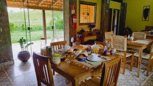 a dining room with a wooden table and chairs at Pousada Campestre Cunha-SP in Cunha