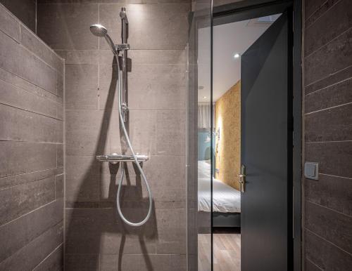 Un baño con ducha con puerta de cristal. en Musea Hotel & Apartments, en Ámsterdam