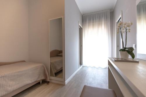 a bedroom with a mirror next to a bed at Hotel Susy in Rimini