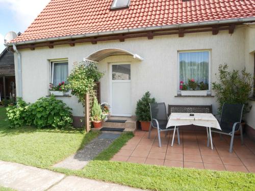 a house with a table and chairs in the yard at Ferienwohnung Kasch in Krummin