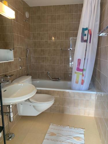 y baño con aseo, lavabo y bañera. en Roc d'Orsay C15, en Leysin