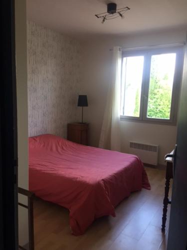 een slaapkamer met een rood bed en een raam bij LE TERTRE CAMILLAC 