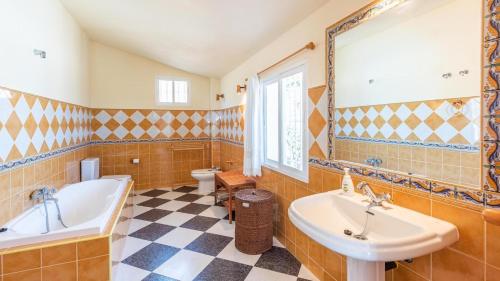 a bathroom with two sinks and a tub and a toilet at Villa el Cerrillo Málaga - Churriana by Ruralidays in Málaga