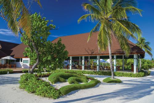 ein Resort mit grünen Hecken vor einem Gebäude in der Unterkunft VARU by Atmosphere - Premium All Inclusive with Free Transfers in Nord-Malé-Atoll