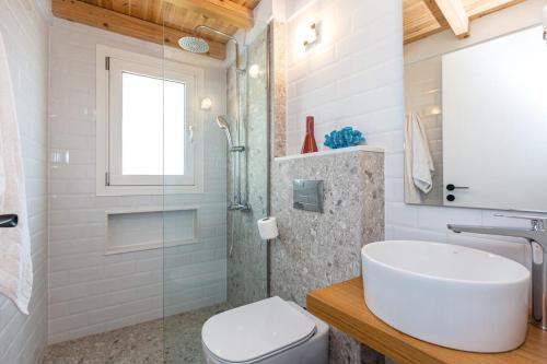 a bathroom with a sink and a toilet and a shower at Nona´s Dorf Haus in Liapades in Liapades