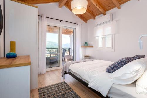 a white bedroom with a bed and a balcony at Nona´s Dorf Haus in Liapades in Liapades