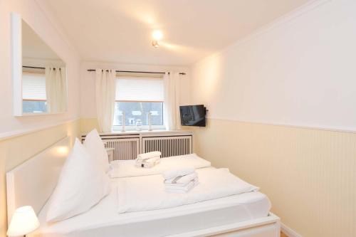 - 2 lits blancs dans une chambre avec fenêtre dans l'établissement Wohnung-Alina, à Westerland
