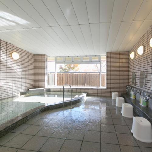 a large bathroom with a large tub and toilets at Kyukamura Chausuyama-Kogen in Toyone