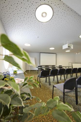 a conference room with chairs and a whiteboard at Klawunn Hotel & Apartement in Kaprun