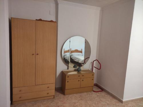 a bedroom with a mirror on a dresser and a bed at CAL TIO PAU in Orba