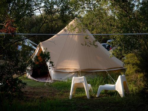 une grande tente avec 2 chaises dans l'herbe dans l'établissement Village Del Mar - Corse, à Solaro