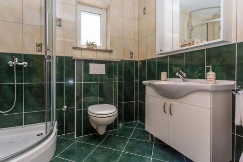 uma casa de banho com um WC, um lavatório e um chuveiro em Apartment Franka em Klimno