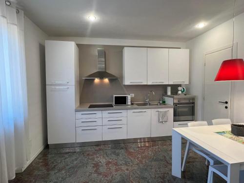 uma cozinha com armários brancos e um forno com placa de fogão em Un nido nel centro storico con garage em Aosta