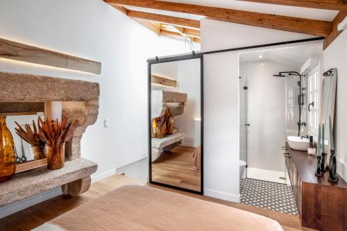 puerta de pivote de cristal en el baño con chimenea de piedra en housingcoruña ELKEL en A Coruña