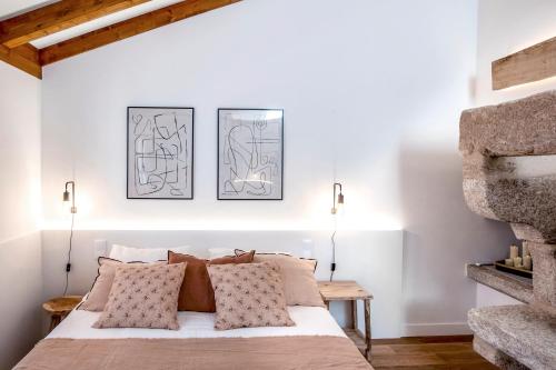 1 dormitorio con 1 cama y 2 cuadros en la pared en housingcoruña ELKEL en A Coruña