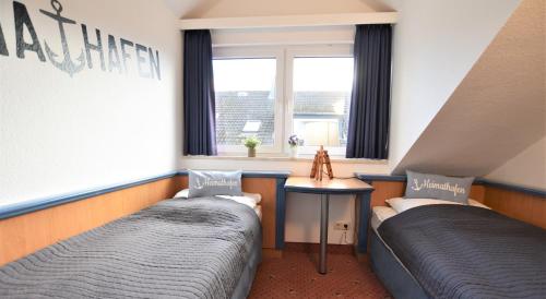two beds in a room with a window at Am Brook 16 Whg 5 in Dahme