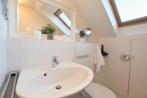a bathroom with a white sink and a toilet at Am Brook 16 Whg 5 in Dahme