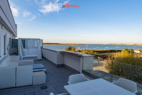 a balcony with white furniture and a view of the ocean at El Anfitrión - Barra del río in Sanlúcar de Barrameda