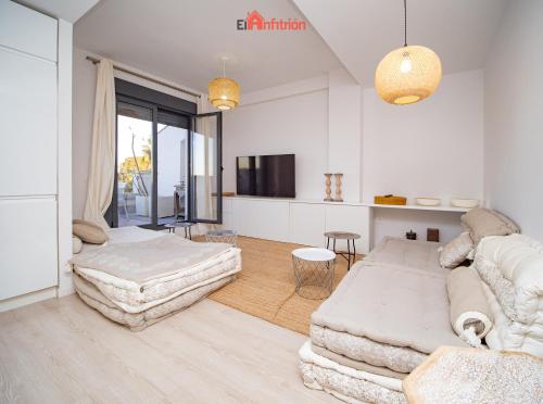 a white living room with a couch and a table at El Anfitrión - Barra del río in Sanlúcar de Barrameda