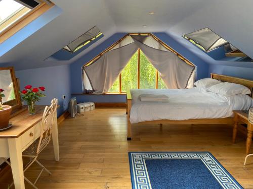 a bedroom with a blue ceiling with a bed and a table at Ralph's Barn in Newport