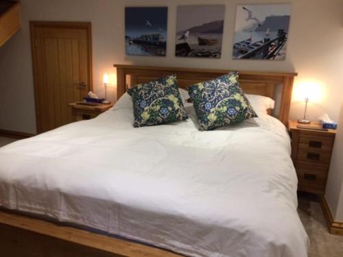 a white bed with two pillows on top of it at River Road, Littlehampton, Executive Apartment in Littlehampton