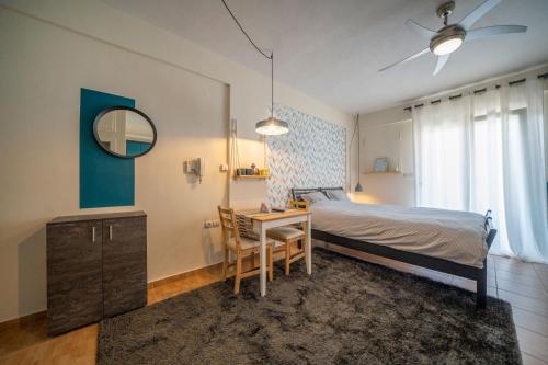 una camera con letto, scrivania e tavolo di The Teal Studio in Kozani a Kozani