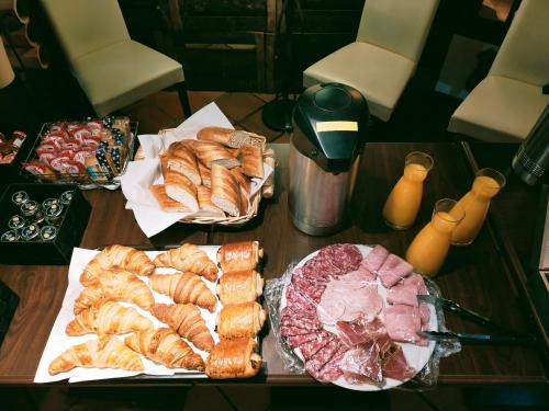 a table topped with different types of bread and pastries at Hôtel Restaurant l’Éolienne in Rouxmesnil-Bouteilles