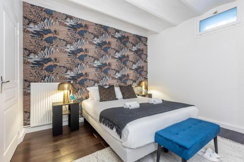 a bedroom with a large bed with a blue stool at Sweet Inn - Friedland in Paris