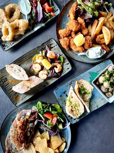 a table with four plates of food on it at Sunset sea view chalet with hot tub in Torpoint