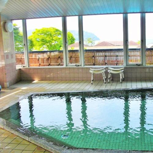 a swimming pool with a bench in a house at Kyukamura Ohmi-Hachiman in Omihachiman