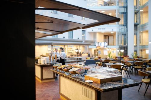 a bakery with a counter with pastries on it at VICTORIA Hotel Klaipėda in Klaipėda