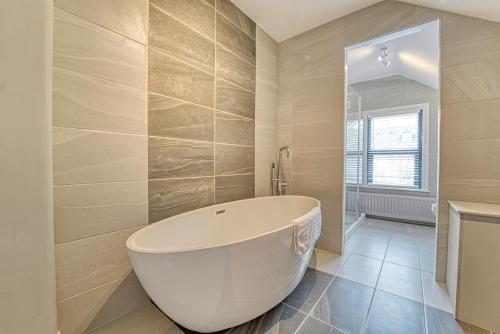 uma casa de banho com uma grande banheira num quarto em Guest Homes - Barton Road House em Hereford