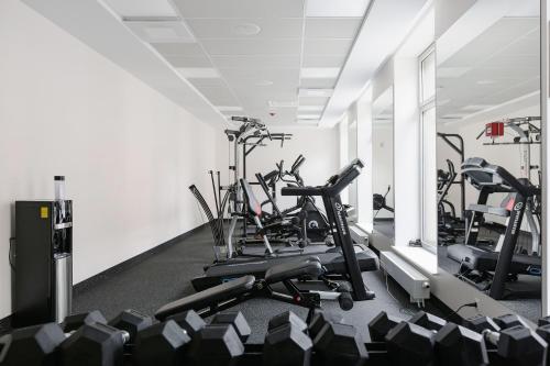 a gym with several tread machines in a room at VICTORIA Hotel Klaipėda in Klaipėda