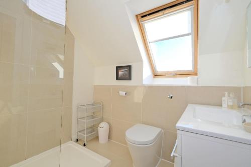 a bathroom with a toilet and a sink and a window at The Loft in Stonehaven