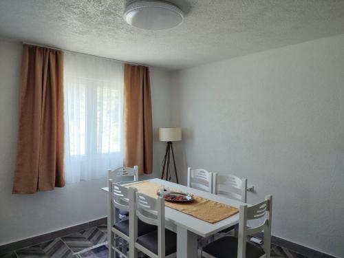 ein Esszimmer mit einem weißen Tisch und Stühlen in der Unterkunft House Bozovic in Žabljak