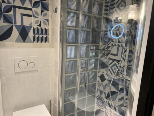 a shower with a glass door in a bathroom at Villette & Canal - Apartment in Paris