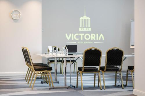 a dining room with a white table and chairs at VICTORIA Hotel Klaipėda in Klaipėda