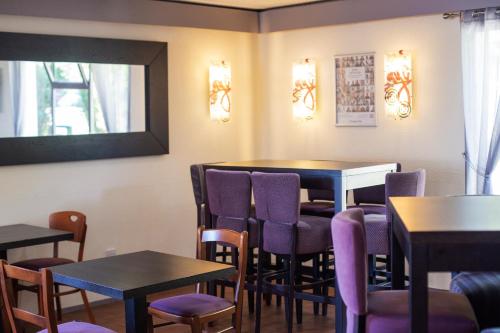 a dining room with purple chairs and tables at The Raceby Hotel, Part of AG Collection in Doncaster