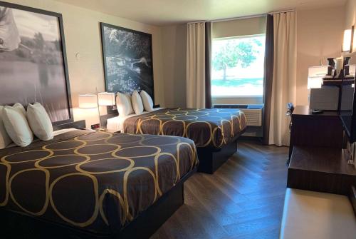 a hotel room with two beds and a window at Super 8 by Wyndham Greeley in Greeley