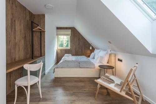 a bedroom with a bed and a table and a chair at Chalupa na mechu in Prostřední Bečva