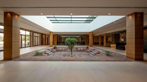 a large lobby with a tree in the middle at Hyatt Place Hampi in Hampi