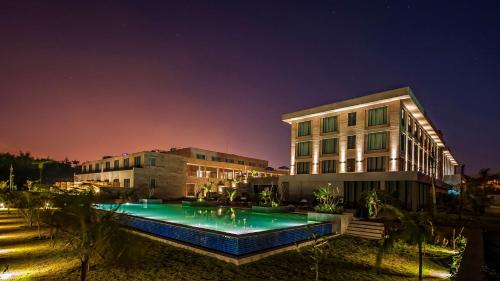 a building with a swimming pool in front of a building at Hyatt Place Hampi in Hampi